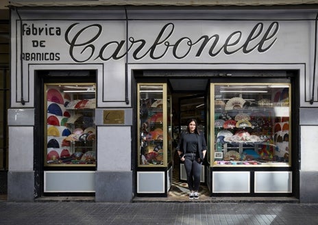 Imagen secundaria 1 - La tienda, con Arturo Carbonell Requena, en la calle Castellón. Paula recrea la misma estampa que su antepasado. Detalle de una tarjeta de presentación de muestrario.