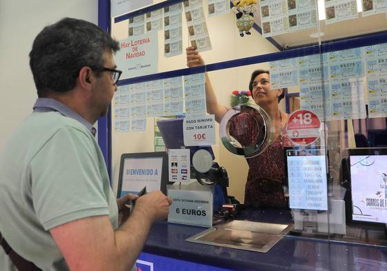 Un participante compra un décimo de lotería en una Administración.