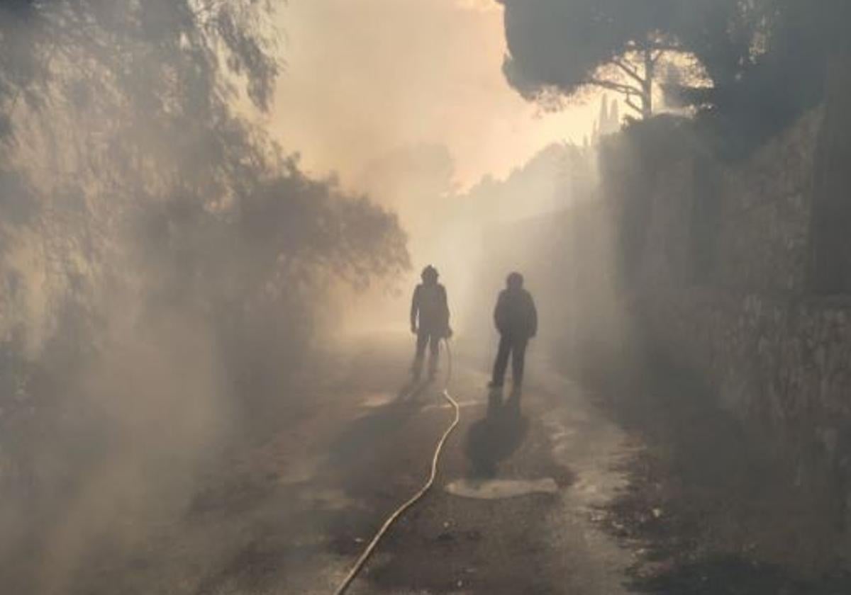 Dos bomberos, en una de las calles de la urbanización.