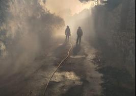 Dos bomberos, en una de las calles de la urbanización.