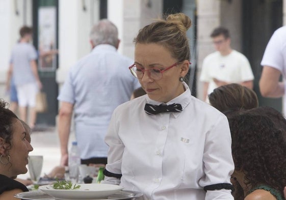 Una camarera sirve a unos clientes en Valencia.