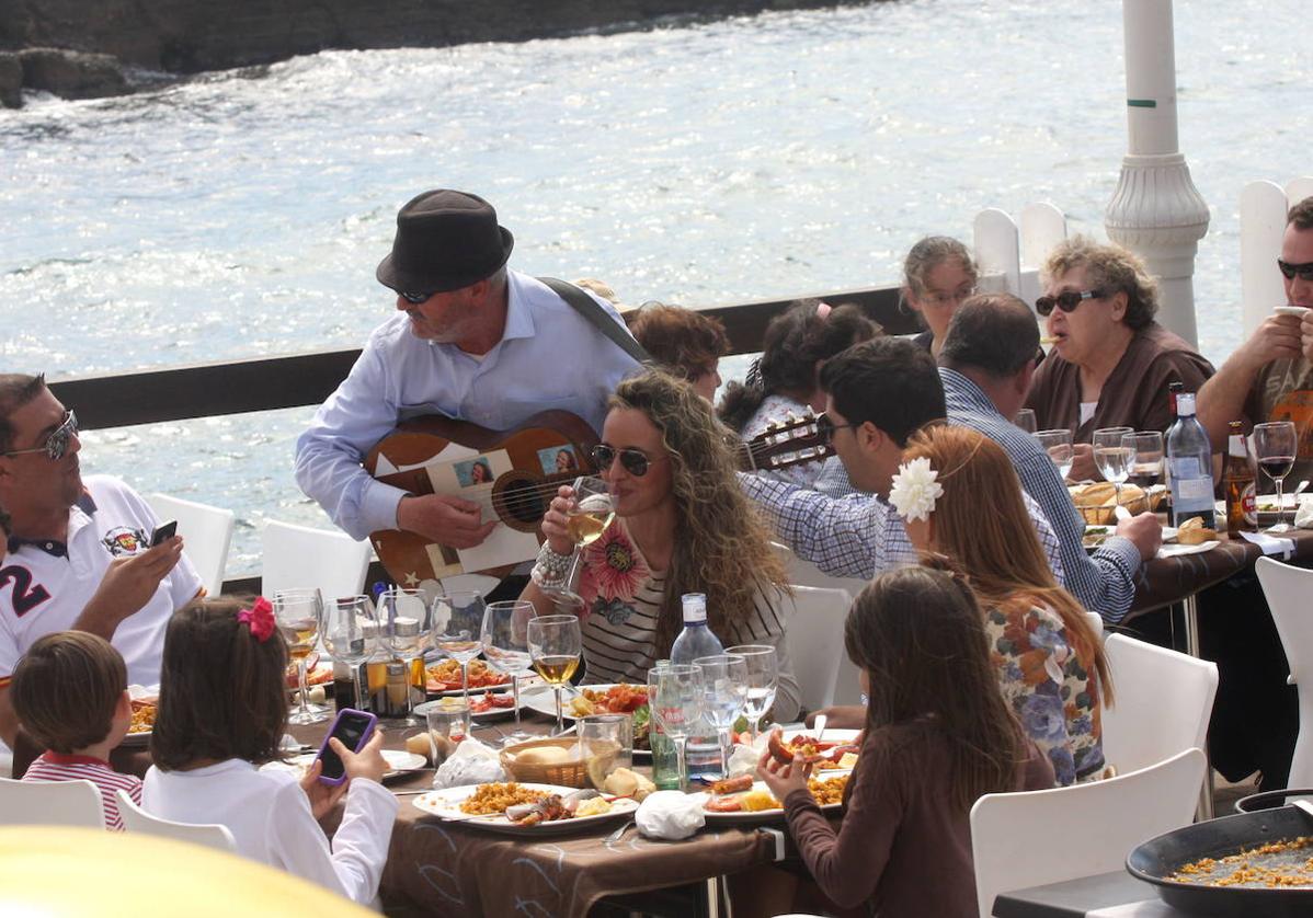 Varias personas comiendo en un restaurante, imagen de archivo.