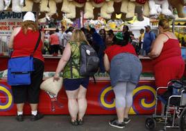 Un grupo de mujeres con obesidad ante una caseta de feria