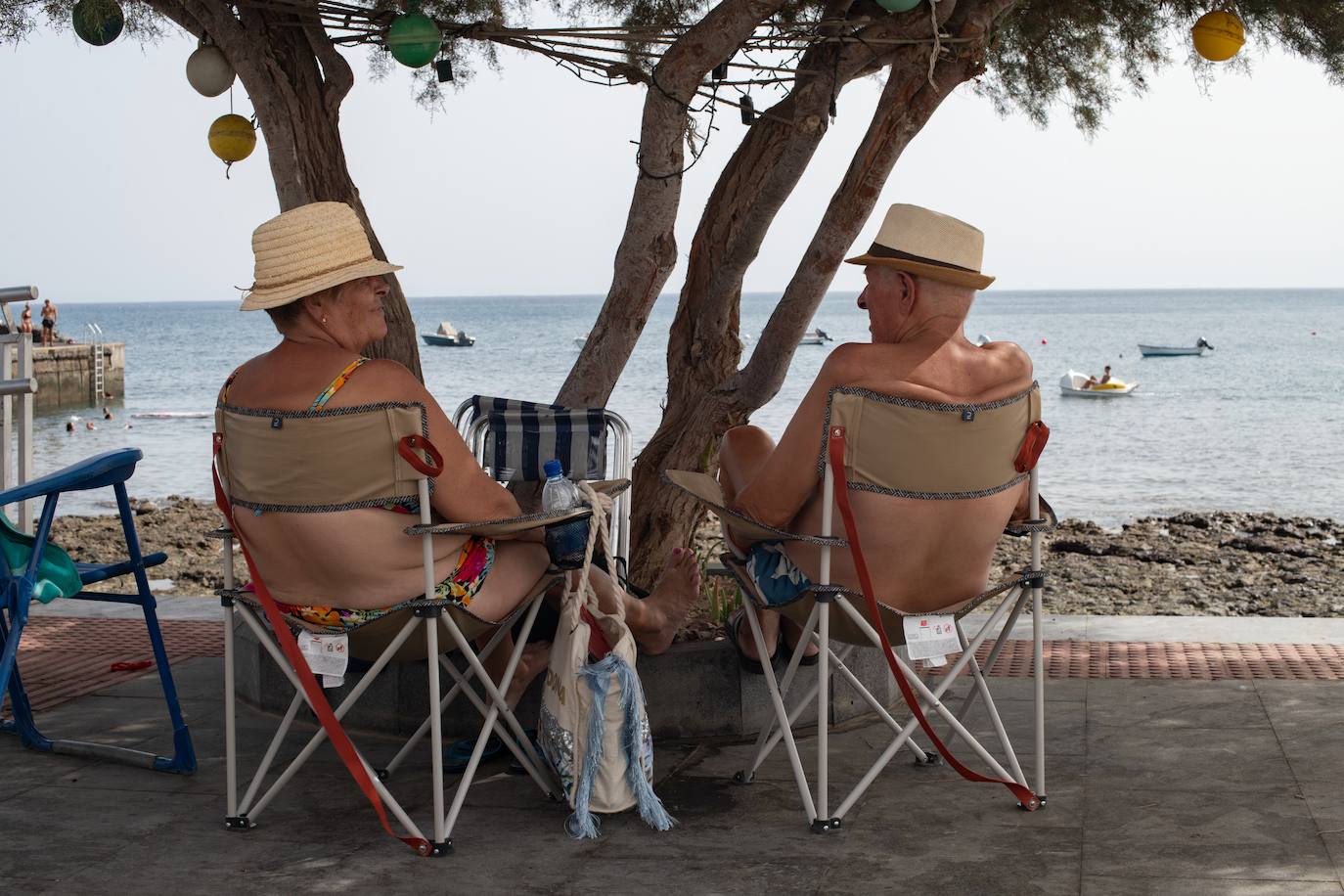 Dos personas se refugian a la sombra de la ola de calor.