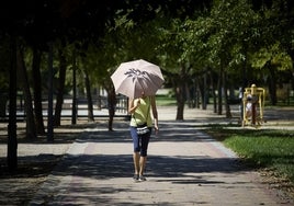 Una mujer se protege del sol con un paraguas.