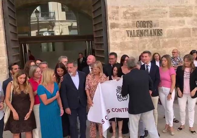 Políticos detrás de la pancarta frente a la puerta de Les Corts.