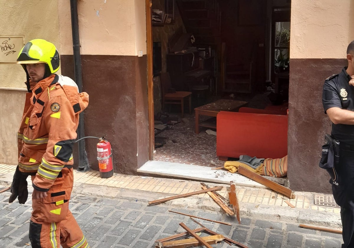 Bomberos y policías junto a los desperfectos de la vivienda de Xàtiva por la explosión de gas.