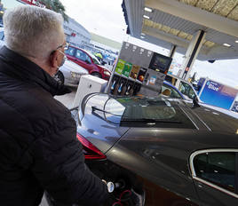 Un hombre reposta en una gasolinera.