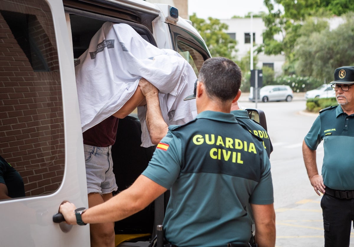 La homicida se tapa la cara con una sábana antes de bajar del furgón.