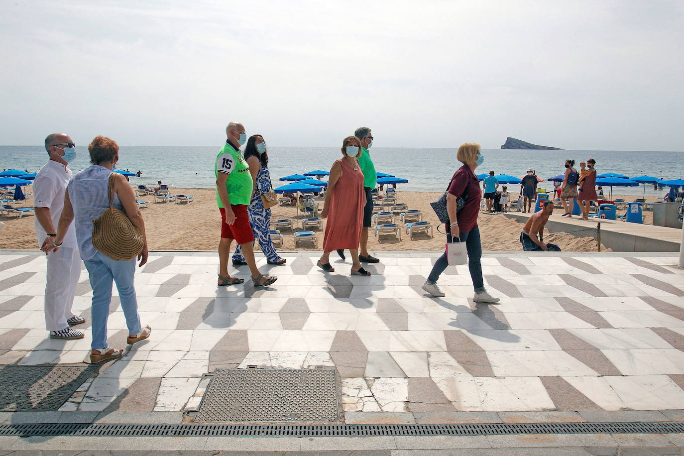 Un grupo de personas pasea por la playa de Levante de Benidorm.