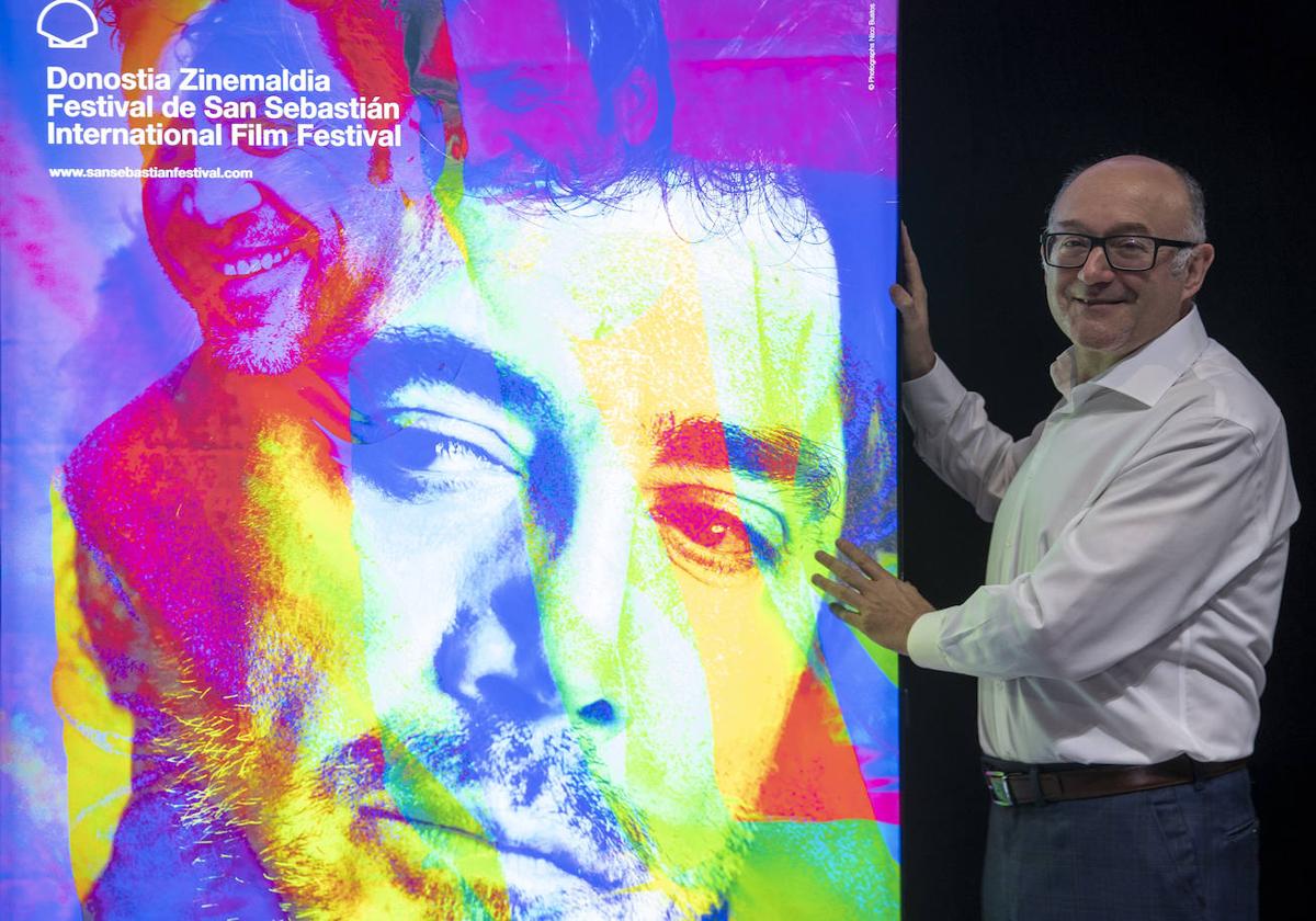 El director del Festival de Cine de San Sebastián, José Luis Rebordinos, posa junto al cartel de la Sección Oficial