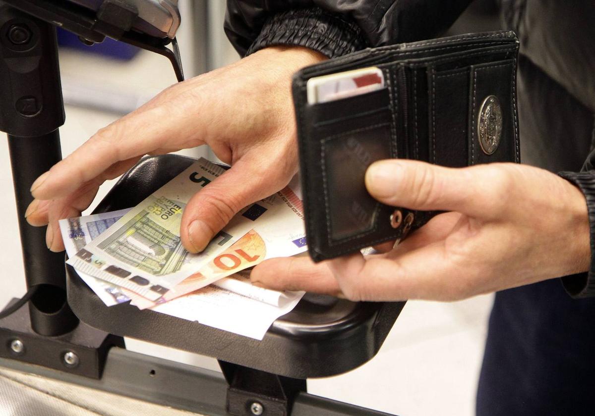 Un hombre recoge varios billetes de diferentes importes.