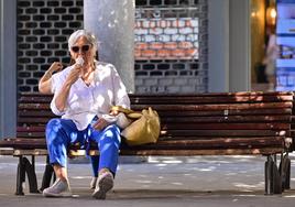 Una mujer disfrutando de un helado en la calle en una imagen de archivo.