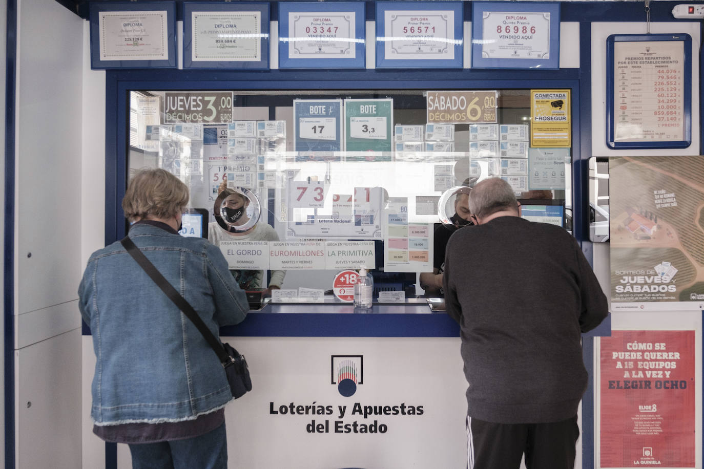 Dos personas comprando en una administración de Lotería.