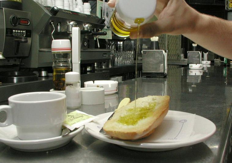 Tostada de pan y aceite tomada con el café en el desayuno en una cafetería.