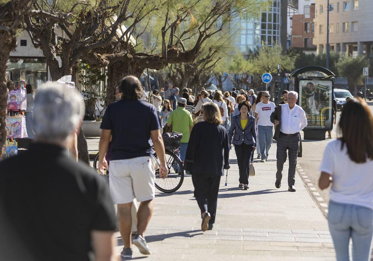 Varias personas caminando por la calle en un día otoñal, imagen de archivo.