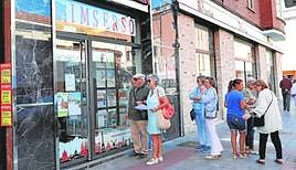 Una agencia de viajes con varios pensionistas esperando en la entrada