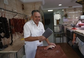 José Gómez corta unas chuletas para sus clientes.