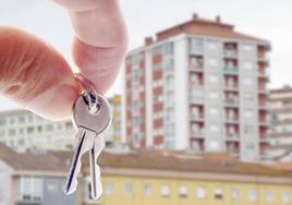 Unas llaves de una casa junto a una vivienda.