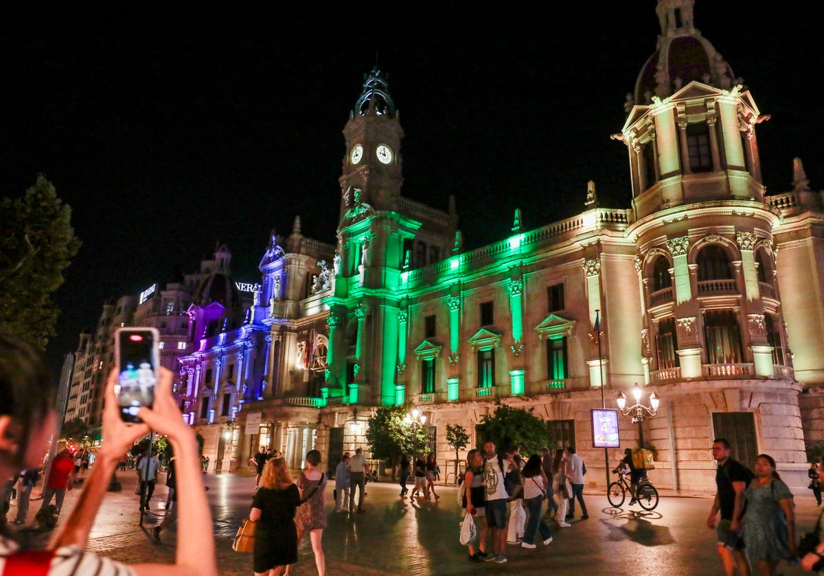 La fachada del Ayuntamiento de Valencia iluminada con los colores del cáncer de mama metastásico.