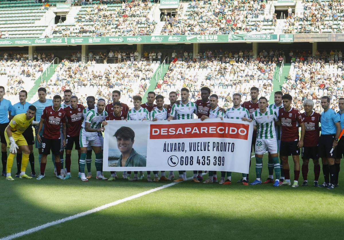 Jugadores del Córdoba y el Mérida sostienen una pancarta en apoyo a la búsqueda del joven Álvaro Prieto, este sábado, en el estadio del Arcángel antes de su encuentro.