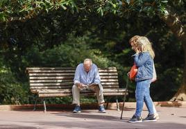 Un jubilado lee el periódico en un parque.