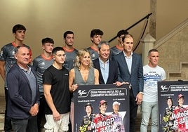 El piloto valenciano Hector Garzó posa junto a más personalidad con el cartel promocional del Gran Premio.