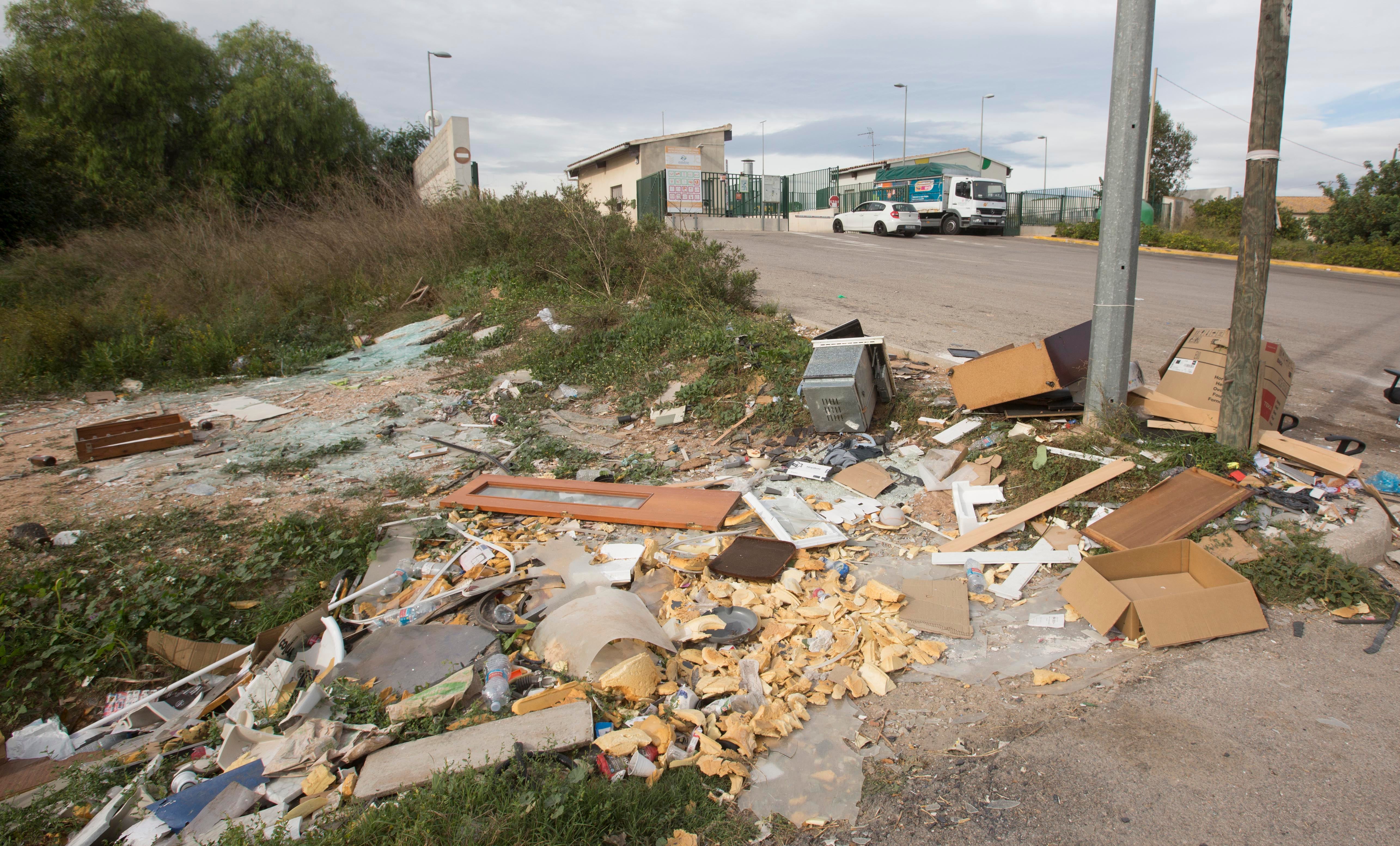 Imagen principal - Arriba, la entrada al ecoparque, tomado por los escombros. Muebles y enseres abandonados en un puente junto a la entrada del polígono.