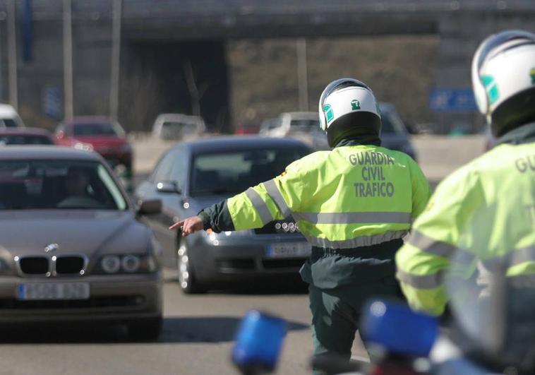 Un agente de la Guardia Civil de Tráfico detiene a los vehículos en un control de carretera.