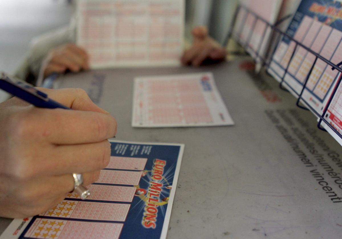 Una mujer rellena un boleto de Euromillones en un despacho de lotería, en una imagen de archivo.