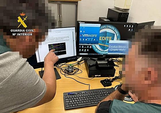 Dos agentes investigan delitos informáticos.