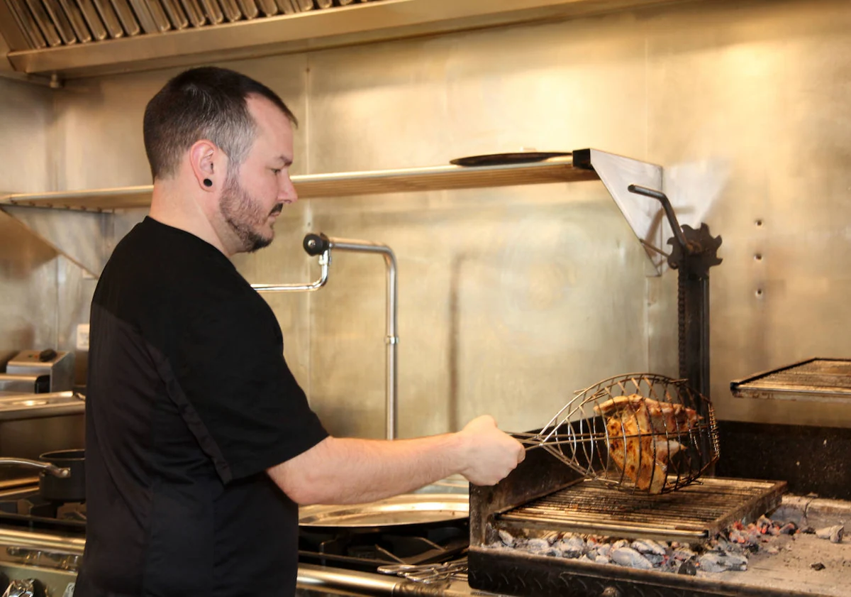 Imagen principal - Miquel Gilabert preparando raya, el pescado emplatado e Irene regando el pan con aceite de Benasau.