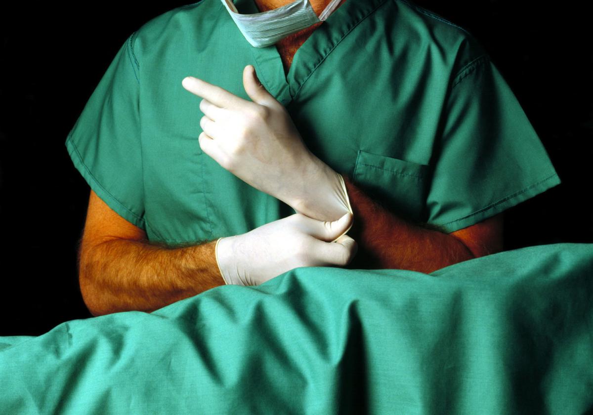Un Cirujano se ajusta los guantes antes de intervenir a un paciente, en una imagen de archivo.