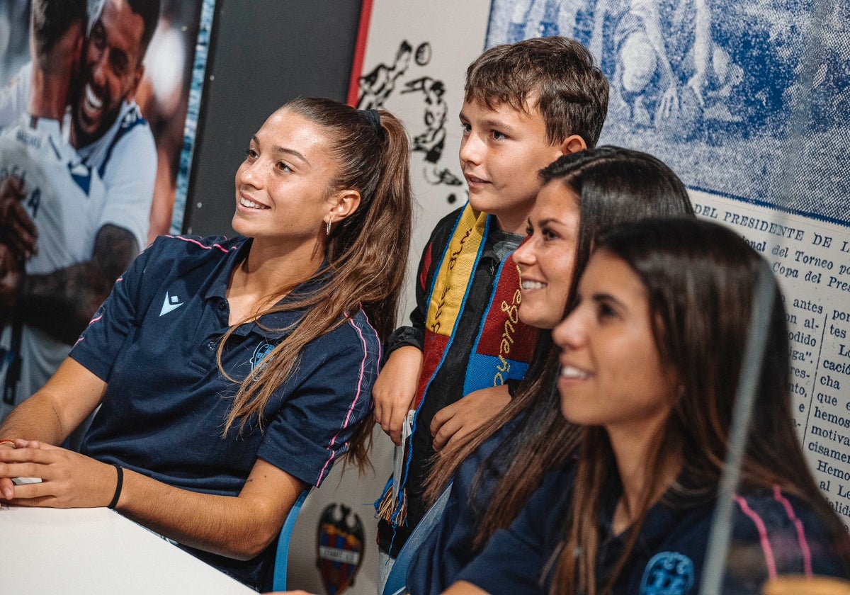 Un joven aficionado del Levante haciéndose una foto con Silvia Lloris, María Méndez y Alba Redondo (de izquierda a derecha).