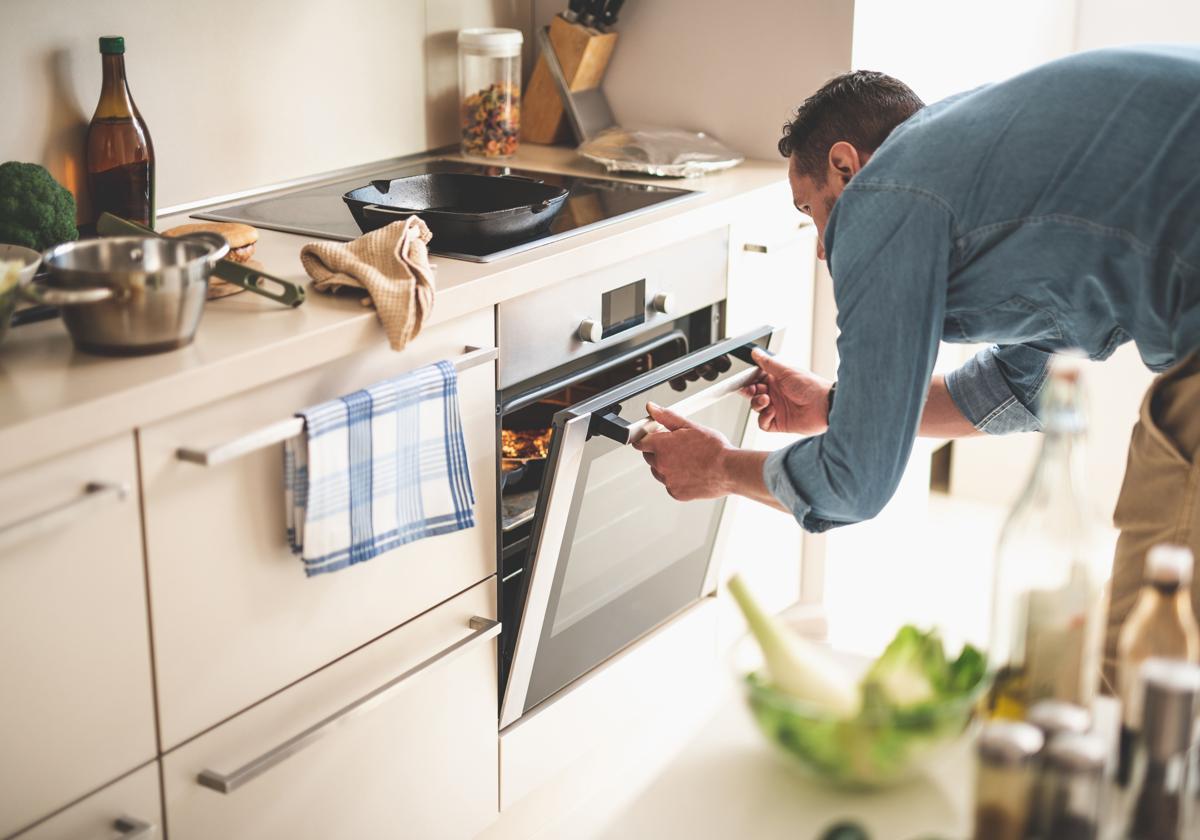 Un hombre cocina en su casa.