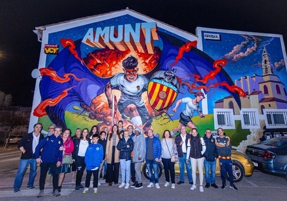 Los aficionados junto al mural de Gandía.