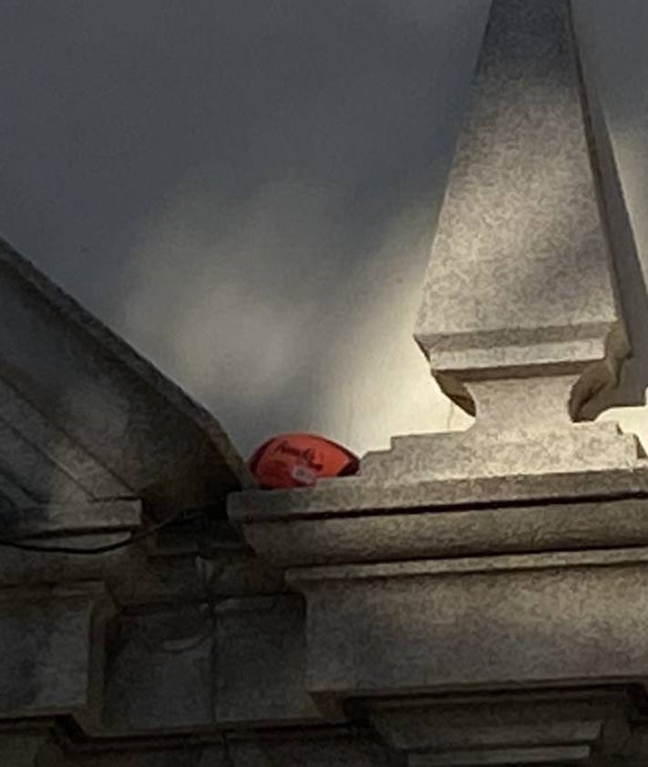 Imagen secundaria 2 - Bolsas de basura tiradas por el suelo; piedras en la zona de acceso a la iglesia y primer plano de un balón de rugby encalado en la fachada.