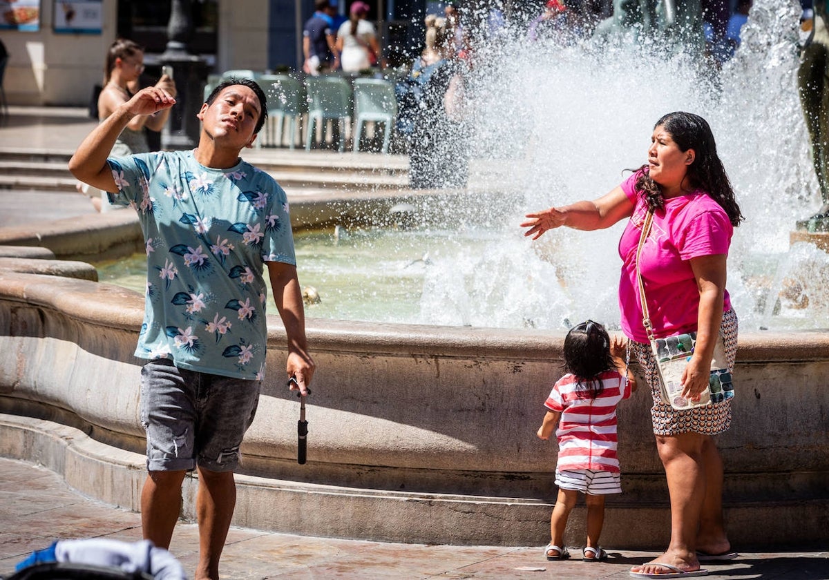 Una pareja se refresca en la plaza de la Virgen.