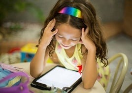 Una niña leyendo en una tablet.