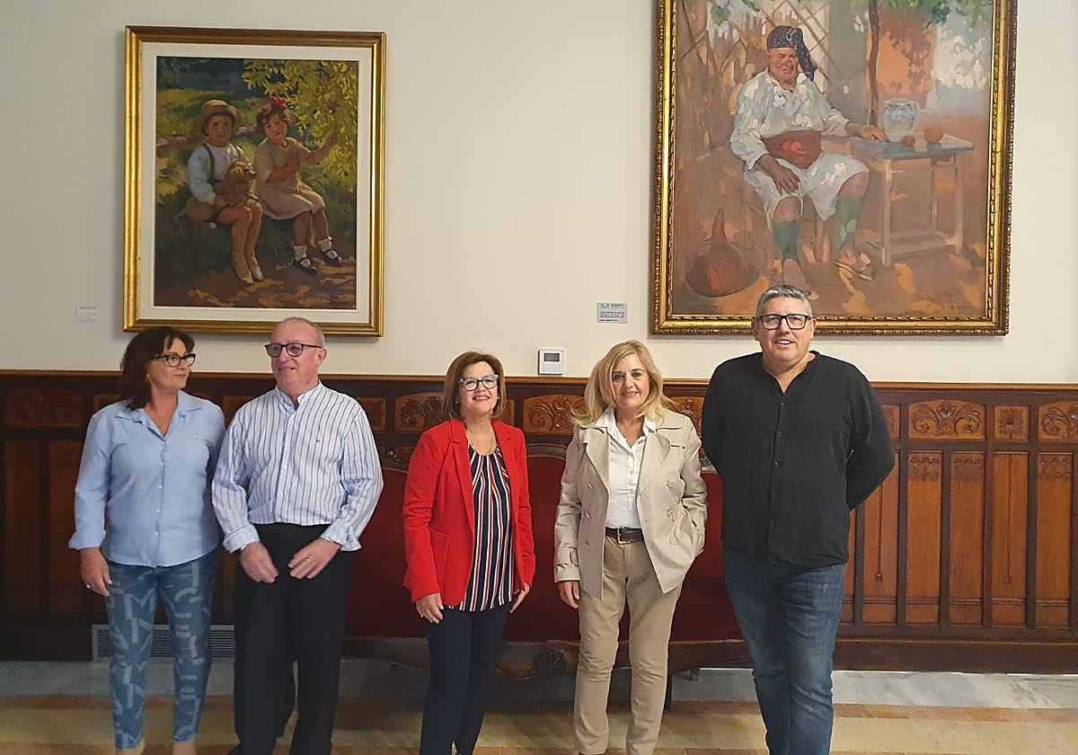 Familiares y representantes municipales junto a los cuadros.