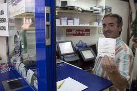 Un responsable de administración de Loterías muestra un boleto. Imagen de archivo.