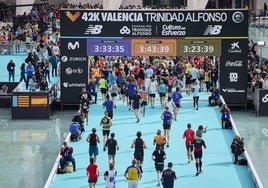 Corredores a su paso por la ansiada alfombra azul que lleva a la meta del Maratón.