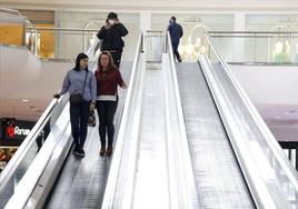 Varias personas en unas escaleras mecánicas de un centro comercial