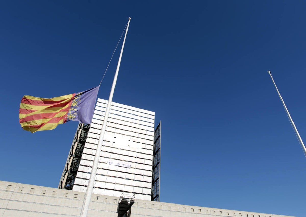 Imagen secundaria 1 - Salida de los trabajadores al exterior tras la desconexión. Abajo, una bandera regional a media asta en la sede de Burjassot y un monitor del estudio ya sin señal.