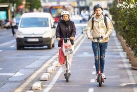 Unas personas van en patinete en Valencia.