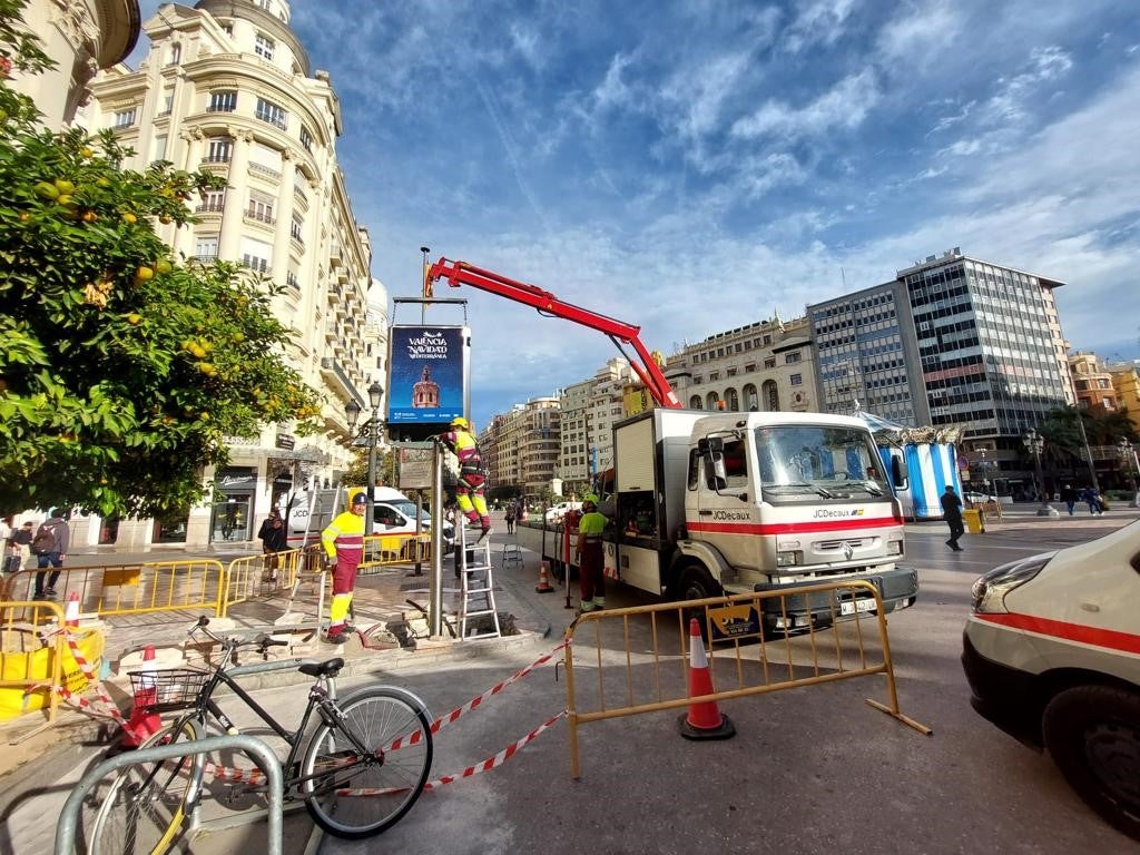 Una grúa instala este jueves uno de los paneles digitales en una de las esquinas del Ayuntamiento.