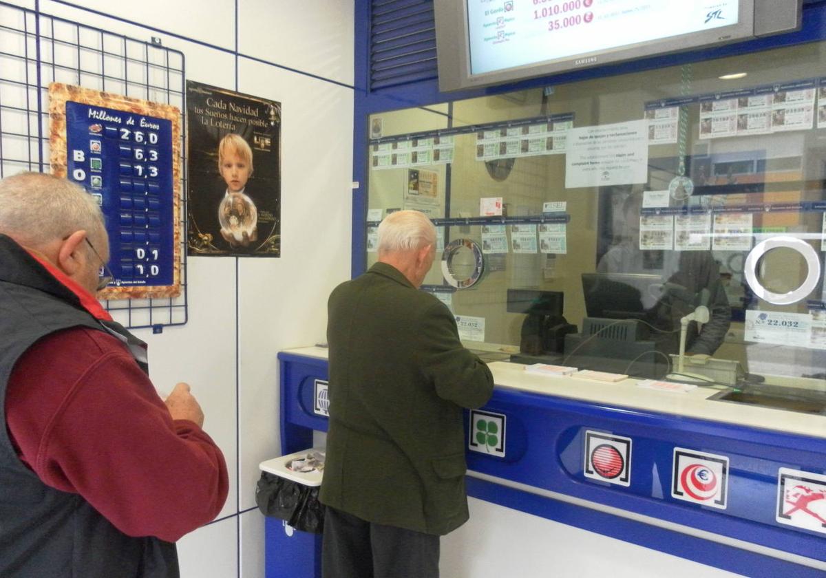 Vecinos compran lotería en una administración.