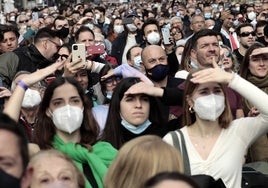 Miles de personas en la mascletà, algunos con mascarilla.