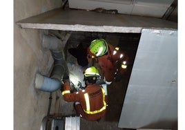 Bomberos rescatando al gato atrapado.