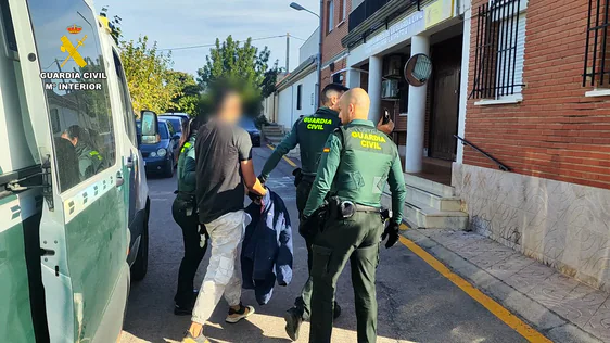 Agentes con uno de los detenidos.